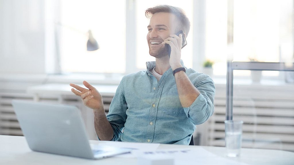 Mann ist glücklich am Telefonieren
